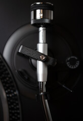 Turntables tone arm in closeup. Professional dj player for vinyl records. Retro style turn table device for disc jockey. Curated collection of royalty free music images and photos for poster design