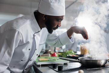 Culinary expert preparing dinner meal service while using fresh vegetables and herbs in restaurant professional kitchen. Skilled gastronomy expert garnishing food with parmesan cheese.
