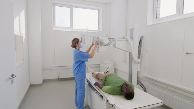 Nurse preparing x-ray for patient joining doctor in office
