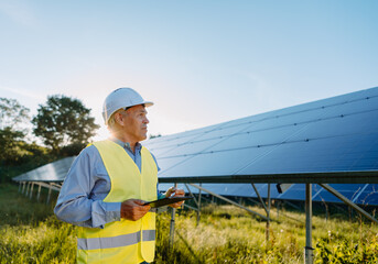 Male engineer using tablet to inspect the solar panels. Eco energy concept