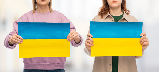 independence day, patriotic and human rights concept - two women holding flag of ukraine on...