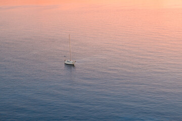 Areal view of seascape view and small ship sailing in sea at sunrise sky 