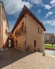 Carrù, Piedmont, Italy - May 17, 2022: Via della Valle with ancient buildings in the historic center and in the background the Castle