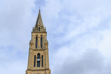 Fototapeta na wymiar Tower of church Notre Dame against blue sky in in Bergerac Dordogne region in Southwest of France