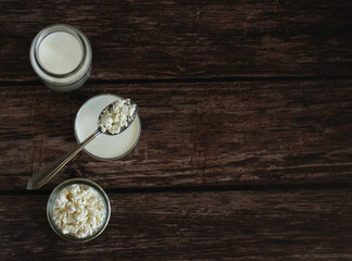 Fototapeta na wymiar homemade cottage cheese with kefir in a glass glass with a spoon on a wooden background