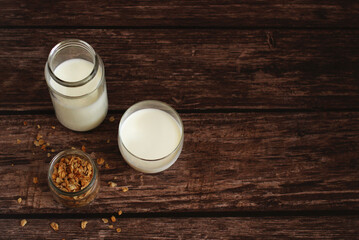 Fototapeta na wymiar fermented milk product kefir in a glass jar with granola on a beige background