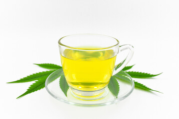 Cannabis herbal tea, Hot cannabis in a glass cup with tea leaves on white background.