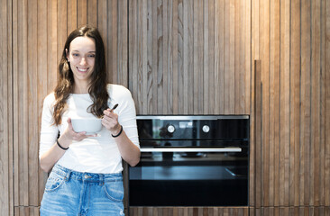 Girl with a bowl of food in the home kitchen. Healthy food, diet concept.