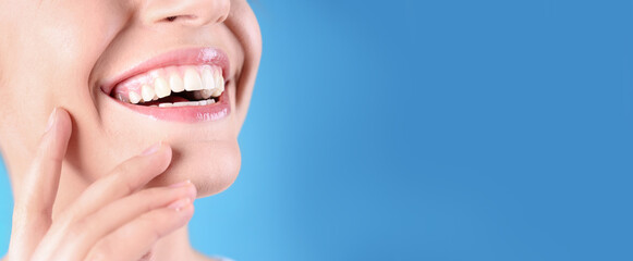 Closeup view of young woman with healthy teeth on blue background, space for text. Banner design