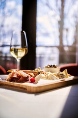 Background of salami, smoked sausage and assortment of cheese. On a black stone background. Free space for your text.