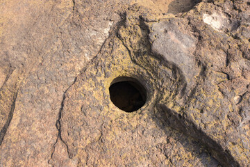 The stone slabs in the dry creek are broken. It is a slit hole because of the long erosion force of natural currents.