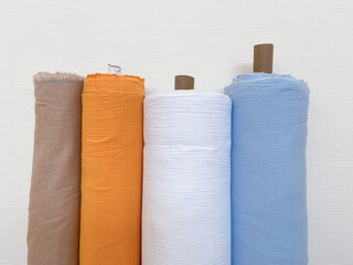 Different colors fabric linen rolls on the white walls, selective focus image