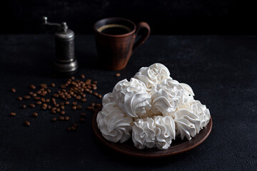 apple marshmallows on a dark background in a plate in the background - a cup of coffee. Coffee drinking concept.