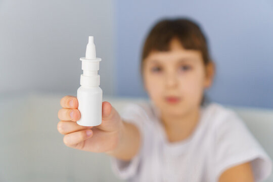 Bottle Of Nasal Spray In Hand Of Girl. Allergy, Viral And Bacterial Rhinitis And Sinusitis Treatment