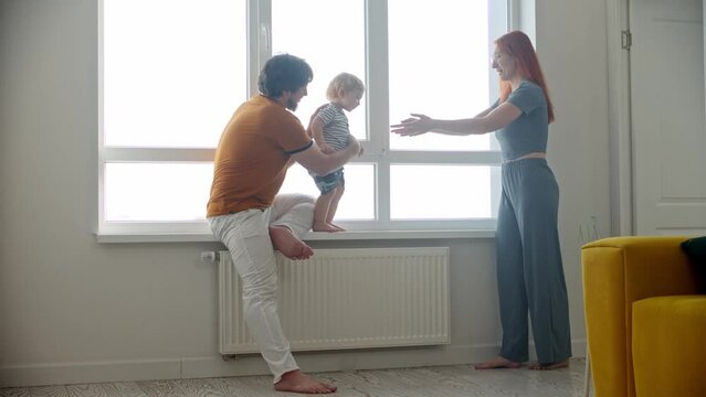 Happy family playing with little baby son running on