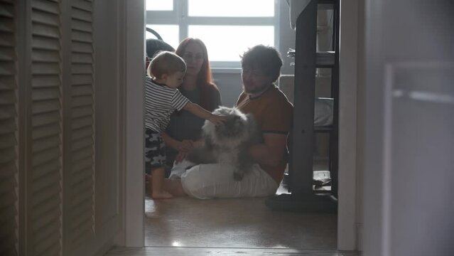 Happy family sitting on the floor and their fluffy