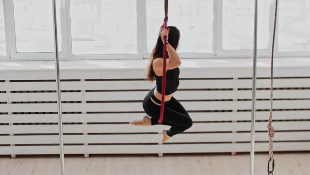 Gymnastic training - young woman doing acrobatic tricks