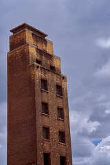 old red brick fire service drill tower or training tower against overcast sky