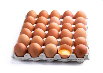 Brown eggs in cardboard tray with one cracked isolated on white