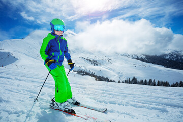 Fototapeta na wymiar Boy ski fast going downhill on the slope in mountains