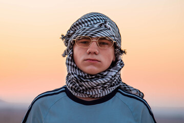 Happy and excited young male tourist portrait against the golden Arabian desert sand dunes in the background.