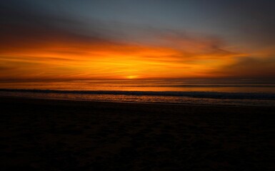 Fototapeta na wymiar Orange sunset at the ocean, empty beach, evening time