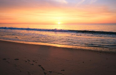 Fototapeta na wymiar Purple sunset at the ocean, empty beach