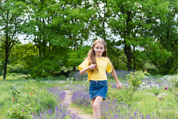 Naklejka na ściany i meble Funny happy little girl in summer outdoors, having fun having fun with cheerful smiling face.