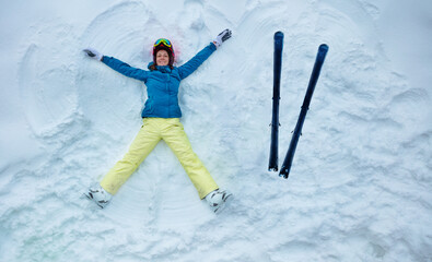 Fototapeta na wymiar Skier woman wear sport coat helmet and mask lay in snow with ski