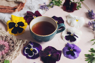 Obraz na płótnie Canvas Cozy morning with cup of tea and viola flowers
