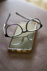 Glasses and mobile phone. Eyestrain. Reading glasses.