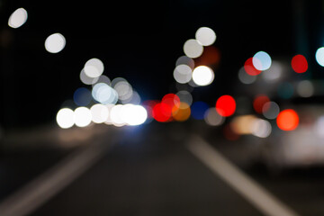 Defocused night street view from drivers perspective, with bokeh blur of street lights. Colorful...