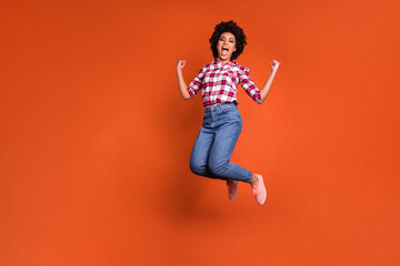 Fototapeta na wymiar Full length photo of carefree positive lady jump high fist up scream yeah lucky win isolated bright color background