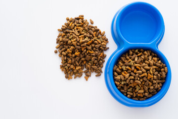 top view of refreshing water in bowl with dry pet food isolated on white.