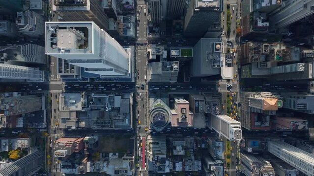 Aerial birds eye overhead top down view of vehicles driving in wide streets at passing through intersections in city divided to regular blocks of buildings. Manhattan, New York City, USA