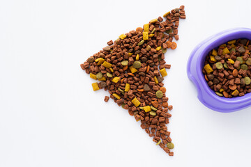shape of fish made with dry pet food near purple bowl isolated on white.