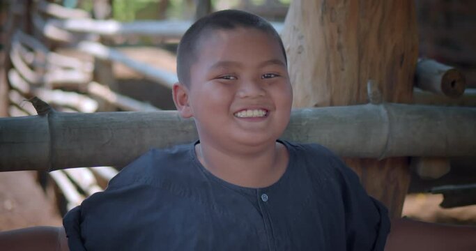 A slow motion scene happy smiling Asian farmer boy wearing traditional clothes.