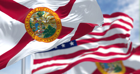 The Florida state flag waving along with the national flag of the United States of America - obrazy, fototapety, plakaty