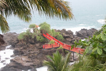 Cilacap, Indonesia Juni, 02 2022, Red Bridge at a beach with black coral, at Menganti Beach Indonesia