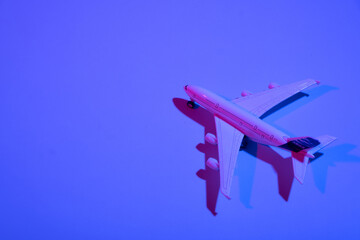 Fototapeta na wymiar Passenger plane toy neon light. Minimalistic concept of air travel, business travel