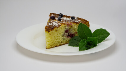 piece of berry pie on a white dish with green mint