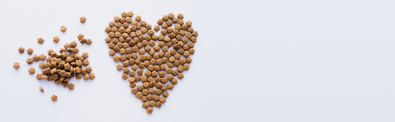 top view of dry pet food in shape of heart isolated on white, banner.