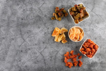 white bowls of candied rheum, pumpkins and cantaloup (rock melon) isolated on grey background flat lay