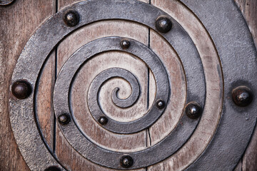 Metal spiral embedded in an old wooden door