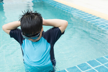 Close-up shot of a boy putting on swim goggles.