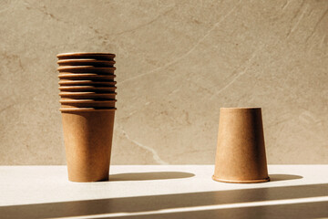 Zero waste concept. Paper glasses on a stone beige background. Front view