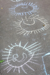 kids chalk sun drawing on the asphalt. High quality close up photo