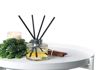 luxury aromatic scent of reed diffuser glass bottle is used as room freshener on white metal table with scented candle to create relax and romantic ambient in bedroom with white cement wall background