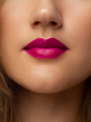 The macro photo of the closed female mouth. Chubby lips with pink lipstick show a fashionable make-up and increase in lips. Cosmetology, Spa, cosmetics