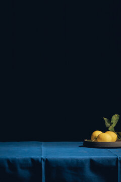 Lemons On The Edge Of The Table With A Blue Tablecloth